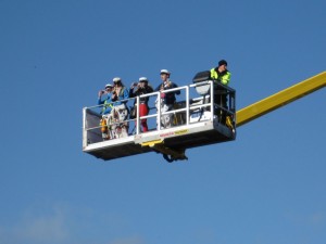 A few people in a skylift high up above the crowds.