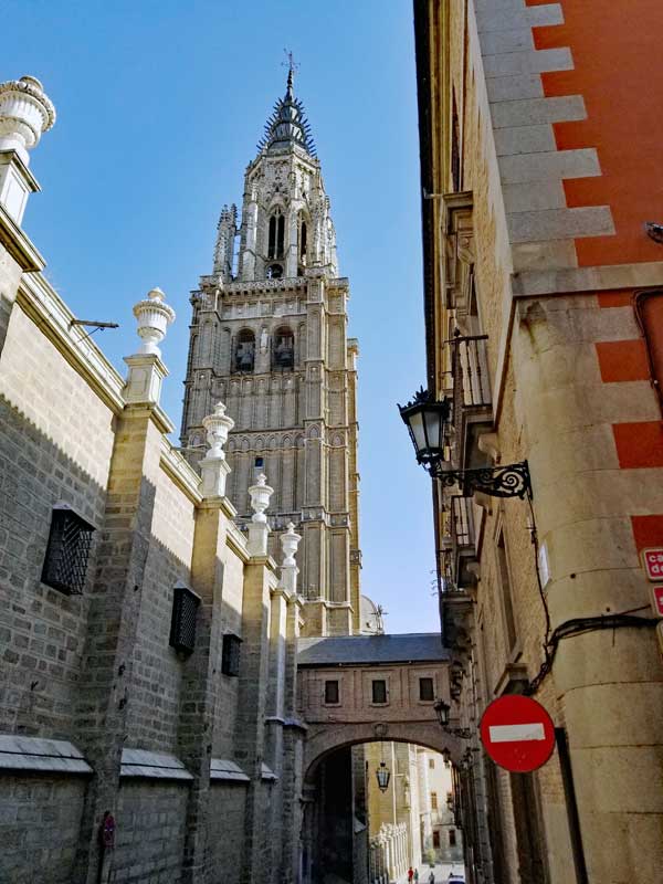 A view down a Toledo street with tower and parts of "The Primate Cathedral of Saint Mary of Toledo" visible.