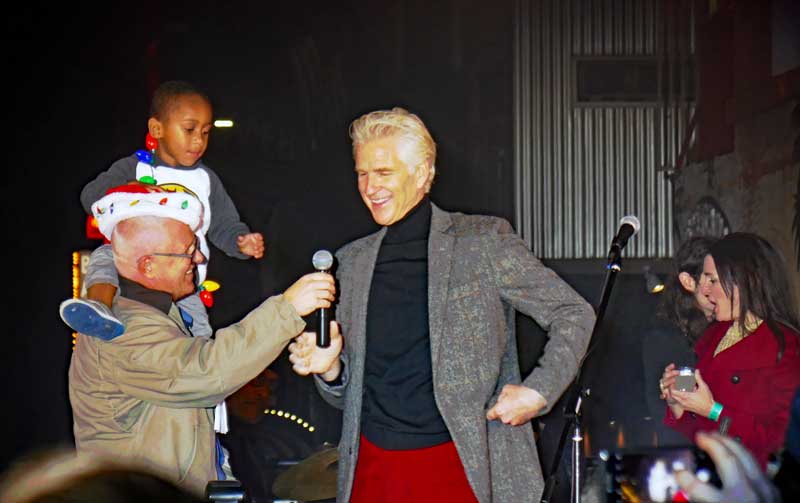 Councilman Mike boning hands the microphone to local actor Matthew Modine for the sign lighting ceremony