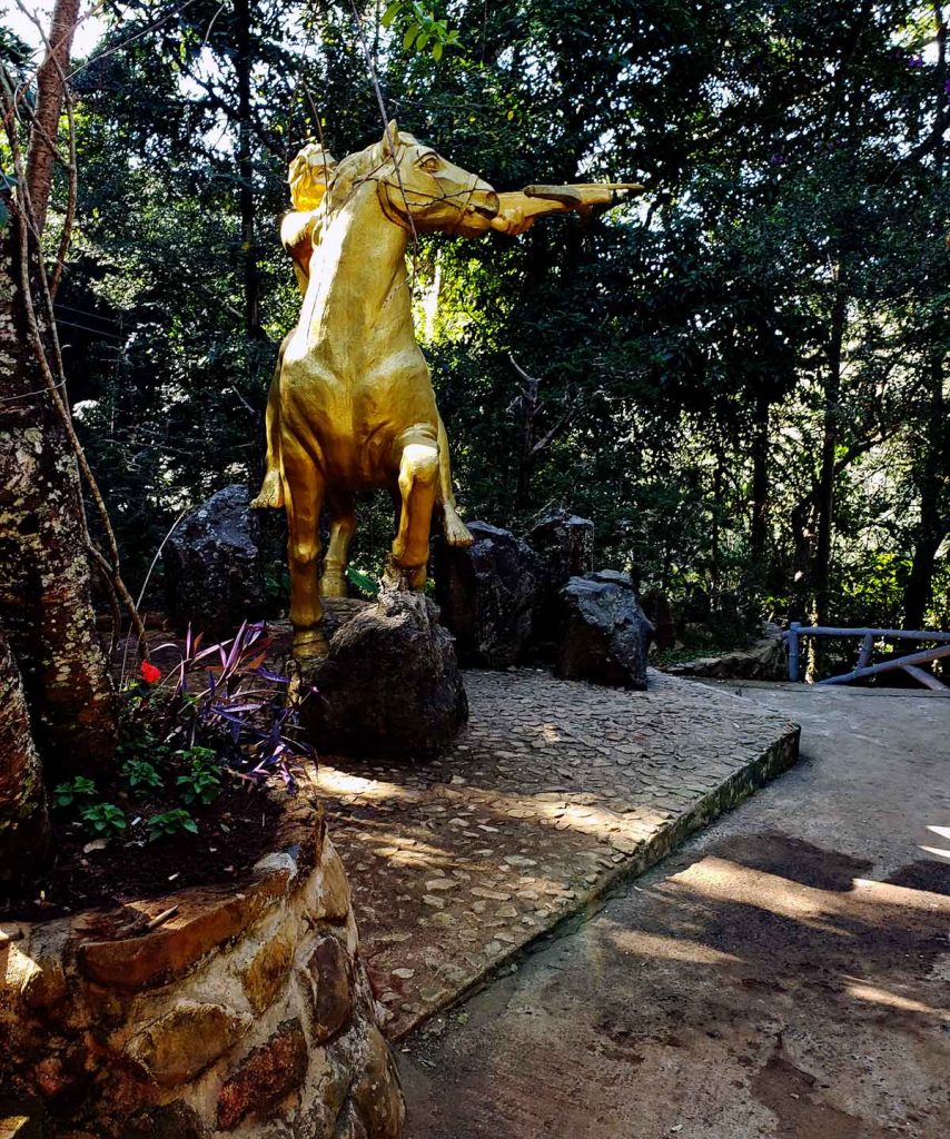 A statue of a golden warrior with a cross bow.
